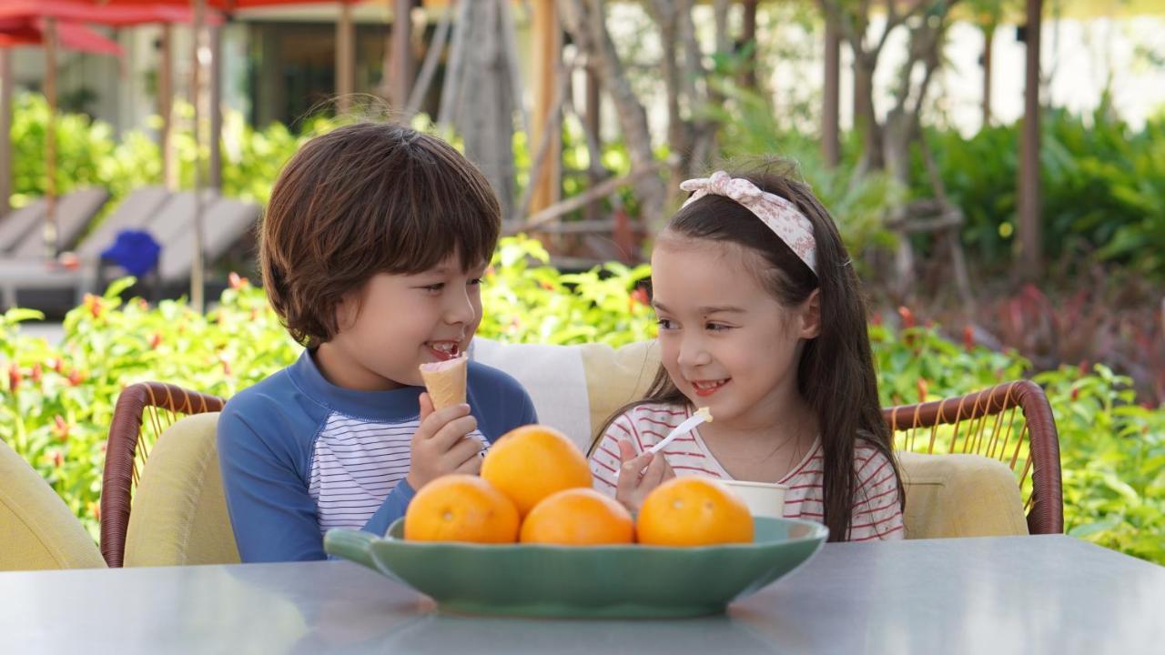 Amari Pattaya Hotell Eksteriør bilde A boy and a girl eating fruit